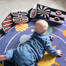Load image into Gallery viewer, Baby playing with a colorful geometric toy on a patterned rug
