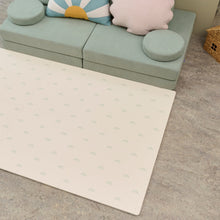Load image into Gallery viewer, Cream play mat with subtle sage rainbow pattern on a concrete floor next to a light green couch with cushions.