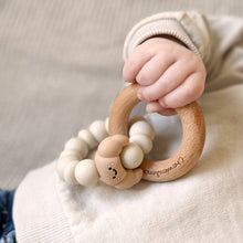 Load image into Gallery viewer, Child's hand holding a wooden teething ring with beads