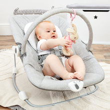 Load image into Gallery viewer, Baby sitting in a gray baby swing holding a toy, with a white crib in the background.