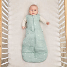 Load image into Gallery viewer, Baby lying in a crib wearing a green sleeping bag with white patterns.