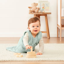 Load image into Gallery viewer, Baby playing with wooden toys on a rug in a room with a teddy bear and a sign in the background.