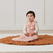 Load image into Gallery viewer, Baby sitting on a brown mat wearing Daisie design ErgoPouch with a white background