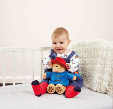 Load image into Gallery viewer, Child sitting on a bed with a teddy bear wearing a blue outfit and red hat