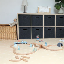 Load image into Gallery viewer, Children's playroom with wooden train set, storage cubes, and toys on a light wood floor.