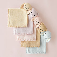 Load image into Gallery viewer, Five soft knitted baby blankets in pastel shades of cream, blush pink, tan, and light blue, each decorated with a matching plush bunny head topper, arranged diagonally on a pale pink background.
