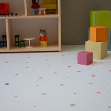 Load image into Gallery viewer, Children's playroom with colorful blocks and toy furniture on a star-patterned floor.