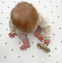 Load image into Gallery viewer, Baby playing with a wooden toy on a white floor with gray triangle patterns
