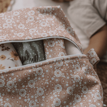 Load image into Gallery viewer, Floral-patterned bag with baby items inside, including a selection of cloth nappies.