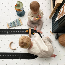 Load image into Gallery viewer, Two children playing with toys on a patterned floor