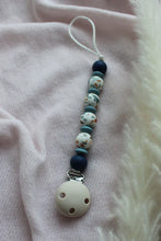 Load image into Gallery viewer, Dummy clip with blue and white beads on a pink fabric background

