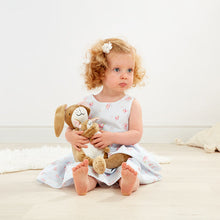 Load image into Gallery viewer, Child holding a teddy bear in a softly lit room
