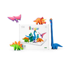 Load image into Gallery viewer, Colorful dinosaur toys in front of a 'Hey Clay' packaging on a white background
