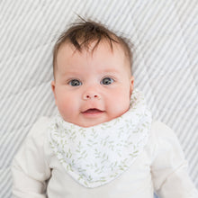 Load image into Gallery viewer, Baby wearing a greenery patterned bib on a textured grey blanket
