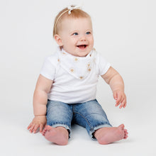 Load image into Gallery viewer, Baby wearing a white bandana bib with sun design, a white t-shirt and blue jeans on a light grey background.
