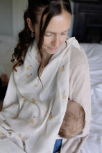 Load image into Gallery viewer, Woman holding a baby wrapped in a pear design muslin.
