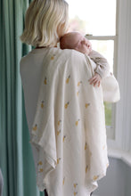 Load image into Gallery viewer, Woman holding a baby with a pear design muslin over her shoulder in a bright natural lit room.
