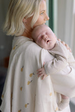 Load image into Gallery viewer, Woman holding a newborn baby with a textured muslin on her shoulder.
