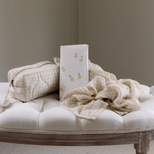 Load image into Gallery viewer, Beige checkered washbag, travel changing mat, and muslin on a white cushioned bench against a grey wall.
