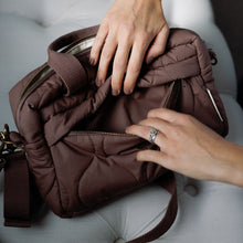 Load image into Gallery viewer, Brown changing bag being held by a person on a light grey surface
