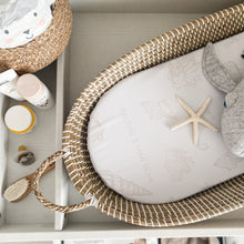 Load image into Gallery viewer, Wicker basket with baby items including a starfish and elephant toy on a shelf.
