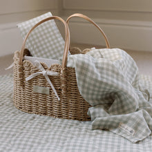 Load image into Gallery viewer, Wicker basket with checkered fabric  muslin and a travel changing mat  in a neutral room.
