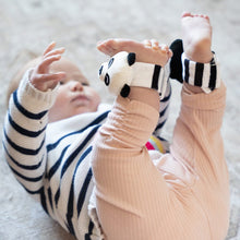 Load image into Gallery viewer, Baby lying on a blanket with striped sleeves and beige pants, wearing ankle rattles.
