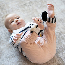 Load image into Gallery viewer, Baby wearing a pink onesie with black and white striped ankle rattles on a neutral background
