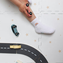 Load image into Gallery viewer, Child playing with toy cars on a road puzzle with a star-patterned background
