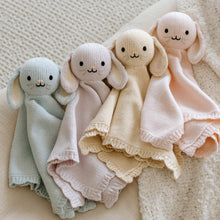 Load image into Gallery viewer, Four knitted bunny baby comfort blankets in different colours on a textured surface

