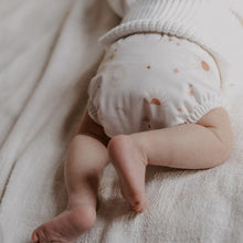 Load image into Gallery viewer, Baby wearing a nappy wrap with celestial pattern on a soft fabric background
