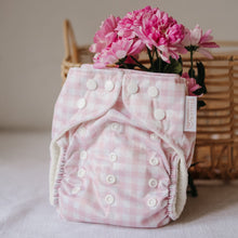 Load image into Gallery viewer, Pink checkered cloth nappy with white buttons on a light surface, accompanied by pink flowers.
