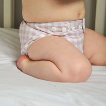Load image into Gallery viewer, Baby wearing a pink checkered cloth nappy on a white surface
