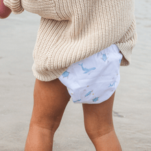 Load image into Gallery viewer, Toddler wearing a beige sweater and cloth nappy with ocean pattern on a beach.
