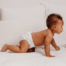 Load image into Gallery viewer, Baby in a white cloth nappy crawling on a white bed
