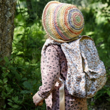 Load image into Gallery viewer, Toddler wearing a colorful knitted hat and floral backpack in a forest setting

