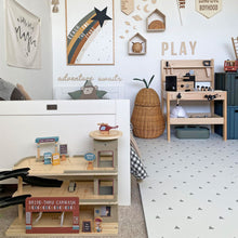 Load image into Gallery viewer, Children's playroom with wooden toys, shelves, and decorative elements.

